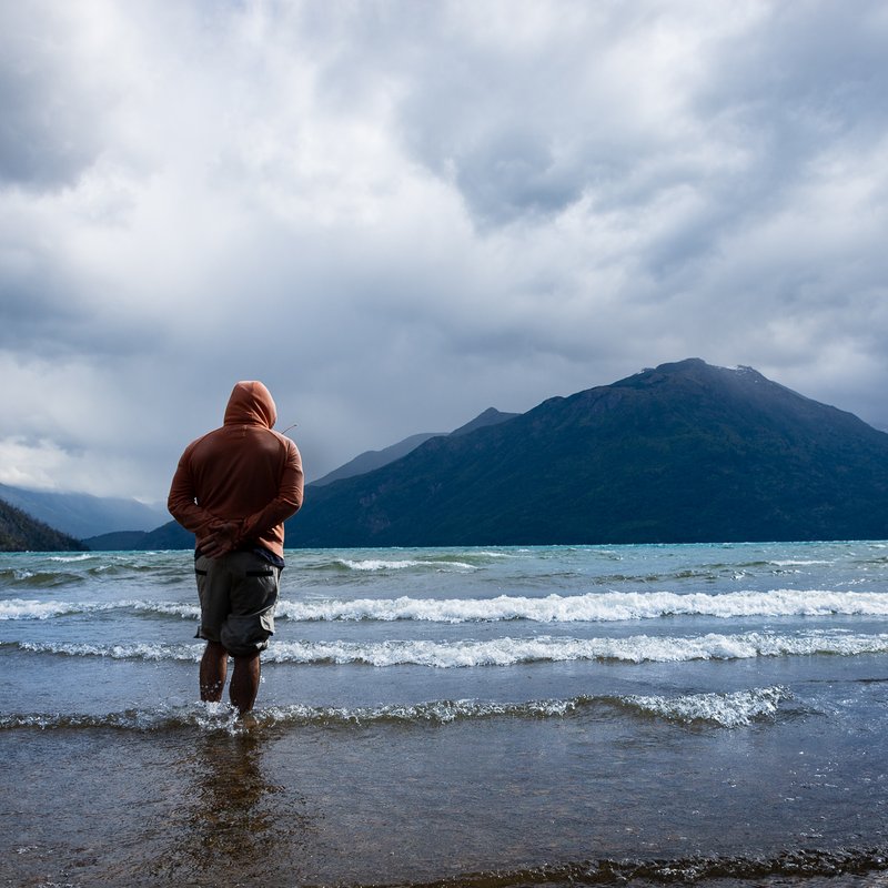 Persona frente al lago Puelo con la cordillera al fondo